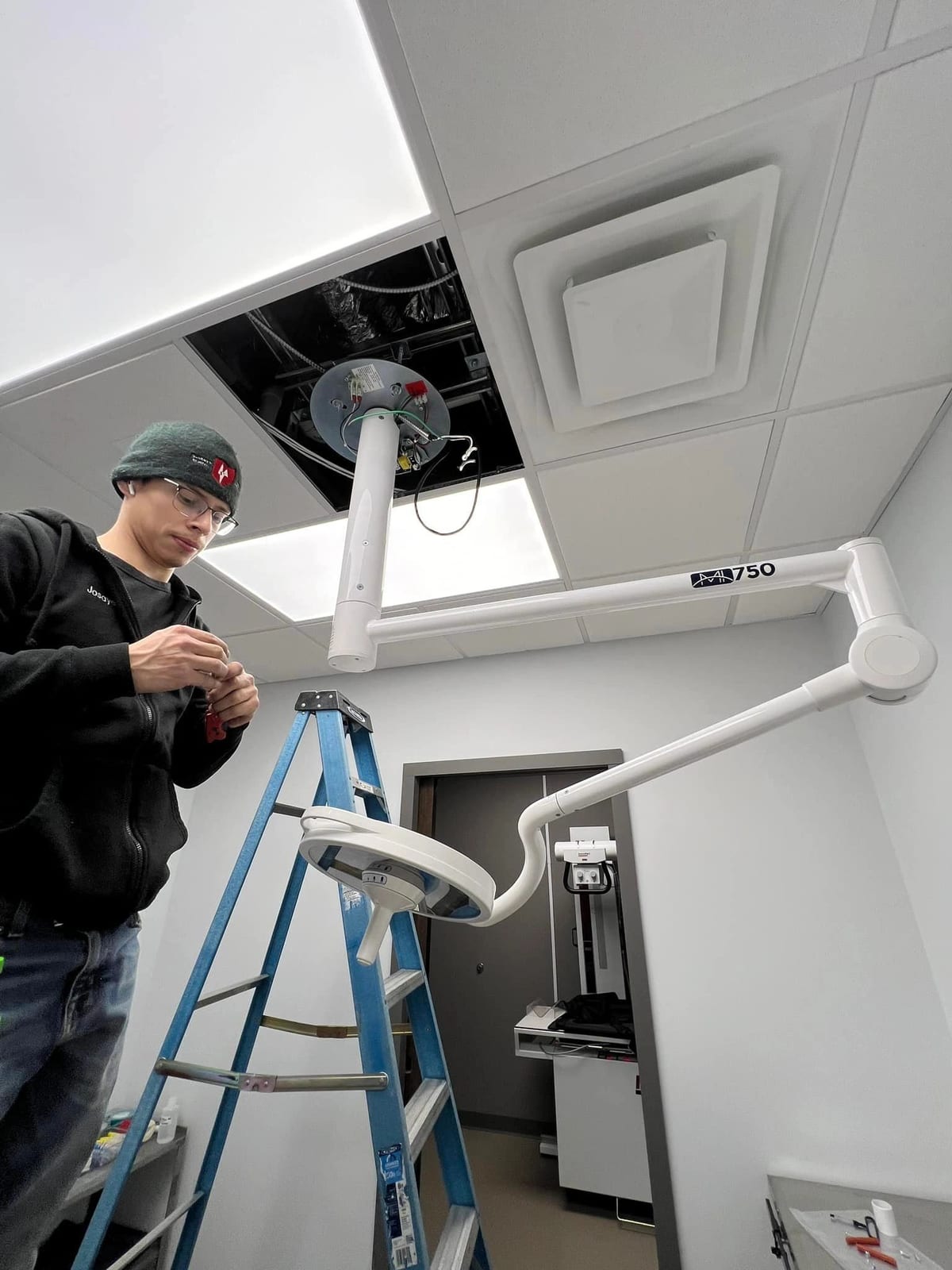Buckeye Electric technician installing an overhead dental examination light in a clinic